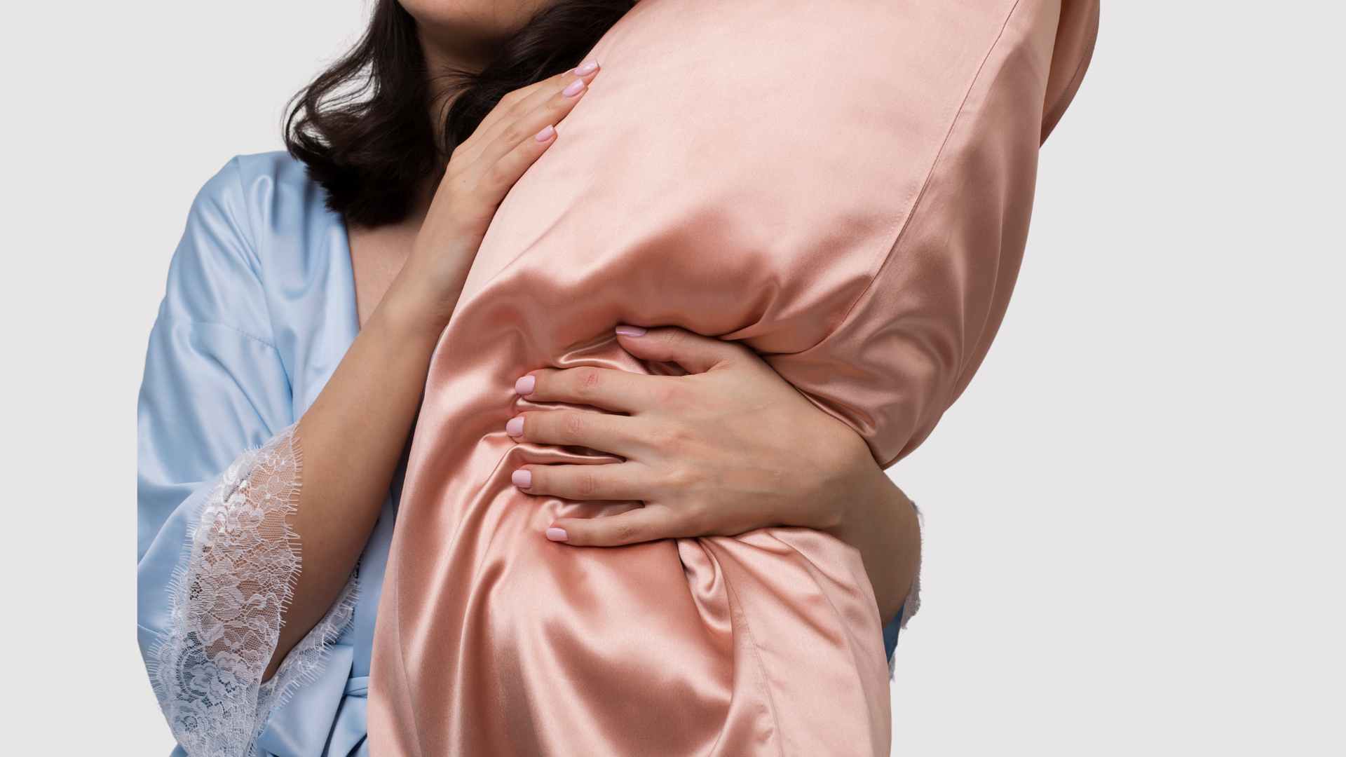 Female holding a satin pillow to prevent split ends