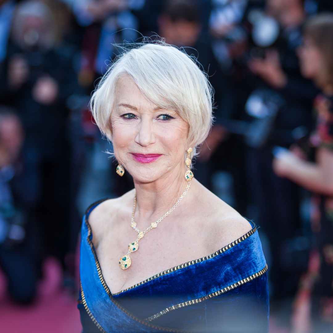 Helen Mirren with grey hair in blue dress at red carpet event