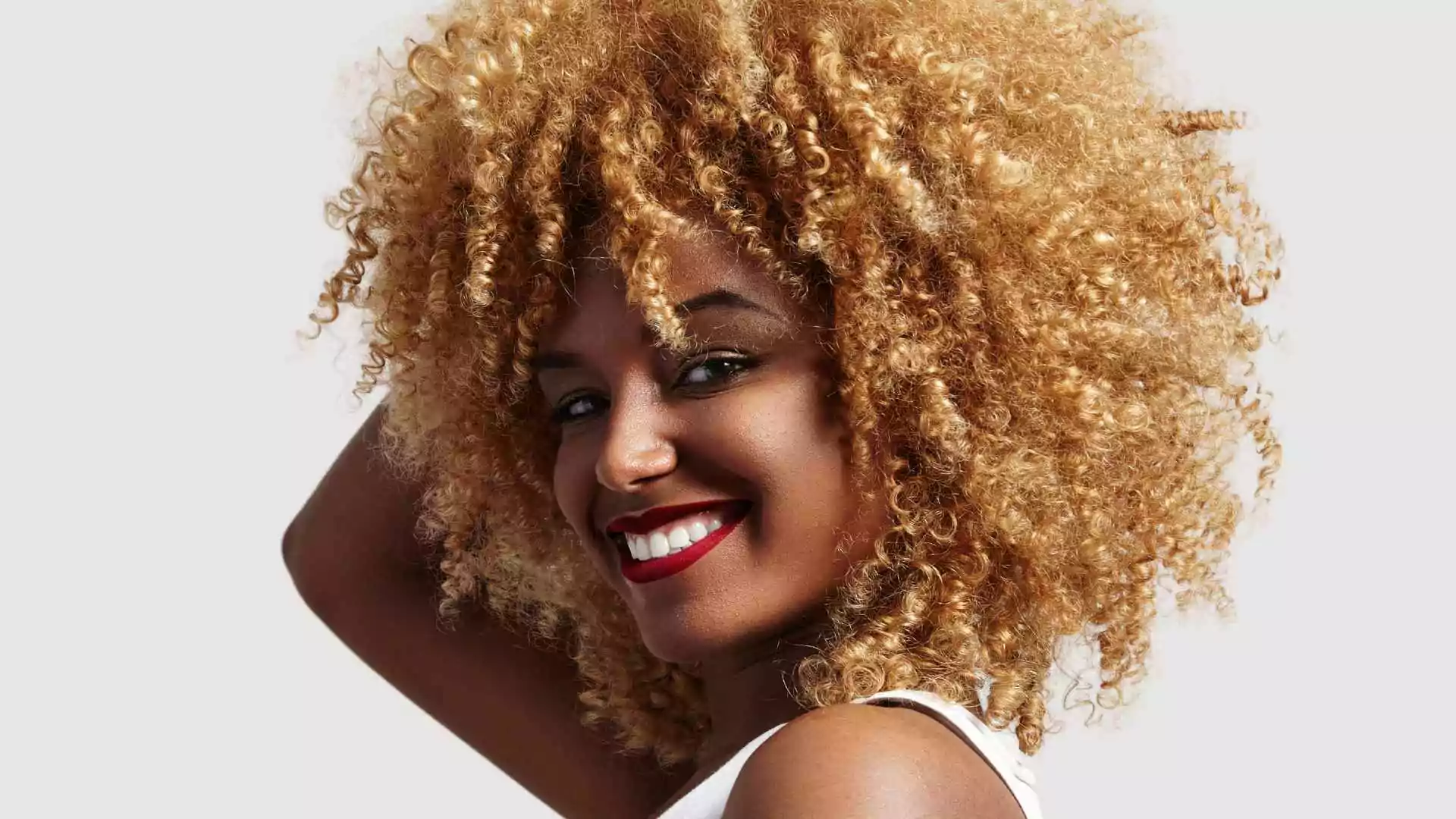 Mujer sonriente con cabello afro decolorado